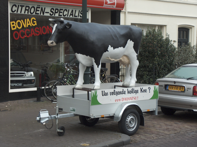 908916 Afbeelding van een kunststof koe op een aanhangwagentje, voor autobedrijf Autoweerd (Weerdsingel O.Z. 42) te ...